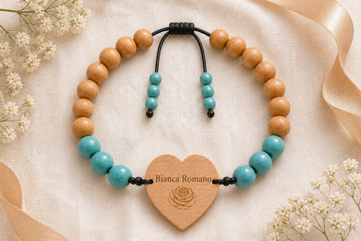 A personalized tap-to-share wedding band with turquoise and amber cypress-wood beads and a heart-shaped wooden tag engraved with the name Bianca Romano, styled on ivory linen with baby's breath and a gold ribbon
